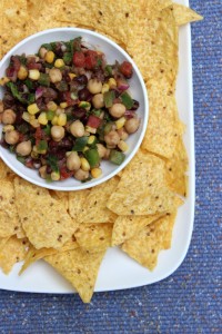 Garbanzo Beans Salsa served in a bowl on a bed of tortilla chips.
